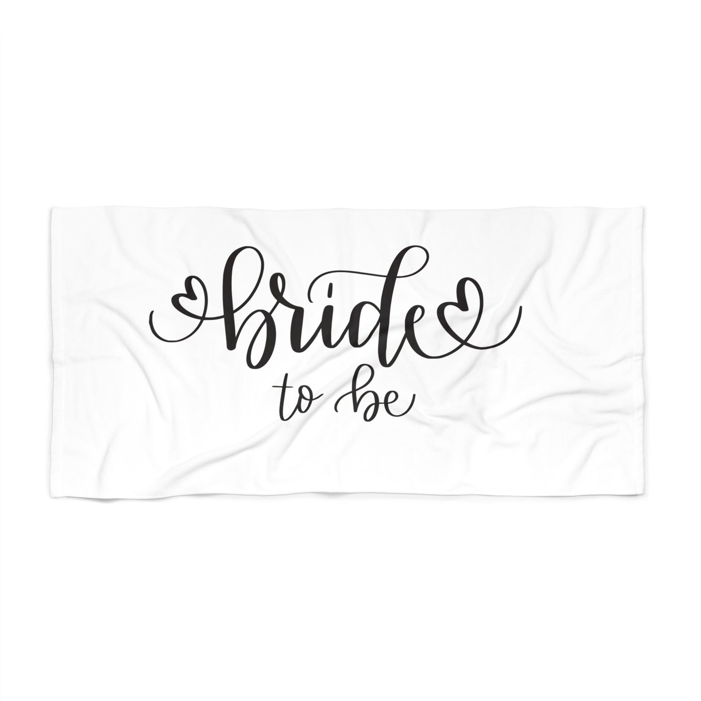 A white beach towel with the phrase 'Bride to be' printed in black cursive text, laying flat.