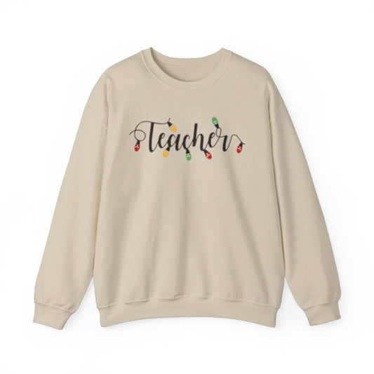 A beige unisex crewneck sweatshirt with 'Teacher' text and Christmas-themed decorations on it.
