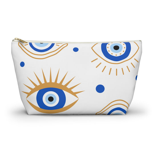 A white polyester pouch with a blue and gold geometric pattern, resembling an evil eye, and a zipper closure.