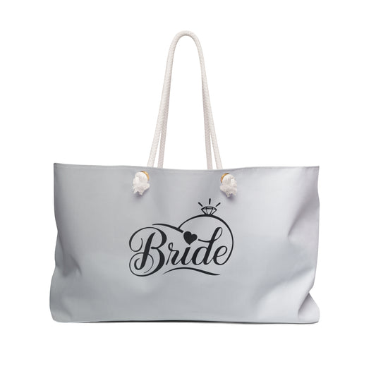 An oversized white weekender tote bag with 'Bride' printed in black on the front, featuring thick rope handles.