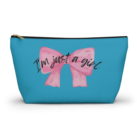 A cosmetic case with a blue background and a pink bow with the text 'I'm just a girl' on it.