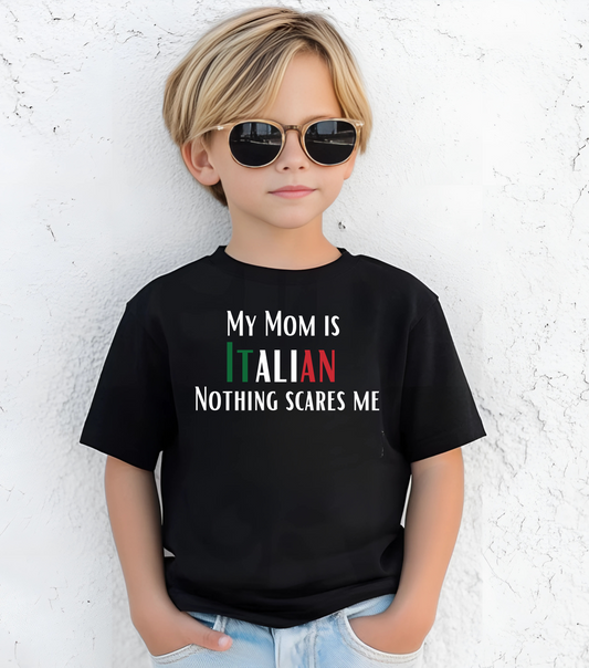 Child wearing a black t-shirt with text standing against a white textured wall