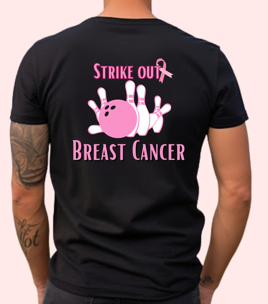 A person wearing a black unisex short-sleeve t-shirt with a pink graphic of a bowling pin and the text 'STRIKE OUT BREAST CANCER' on the front.