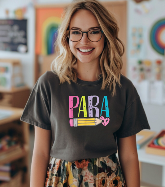 Person wearing a dark gray t-shirt with colorful text in a classroom setting