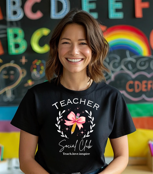 Person wearing a black t-shirt with 'Teacher Social Club' design in front of a colorful classroom background.