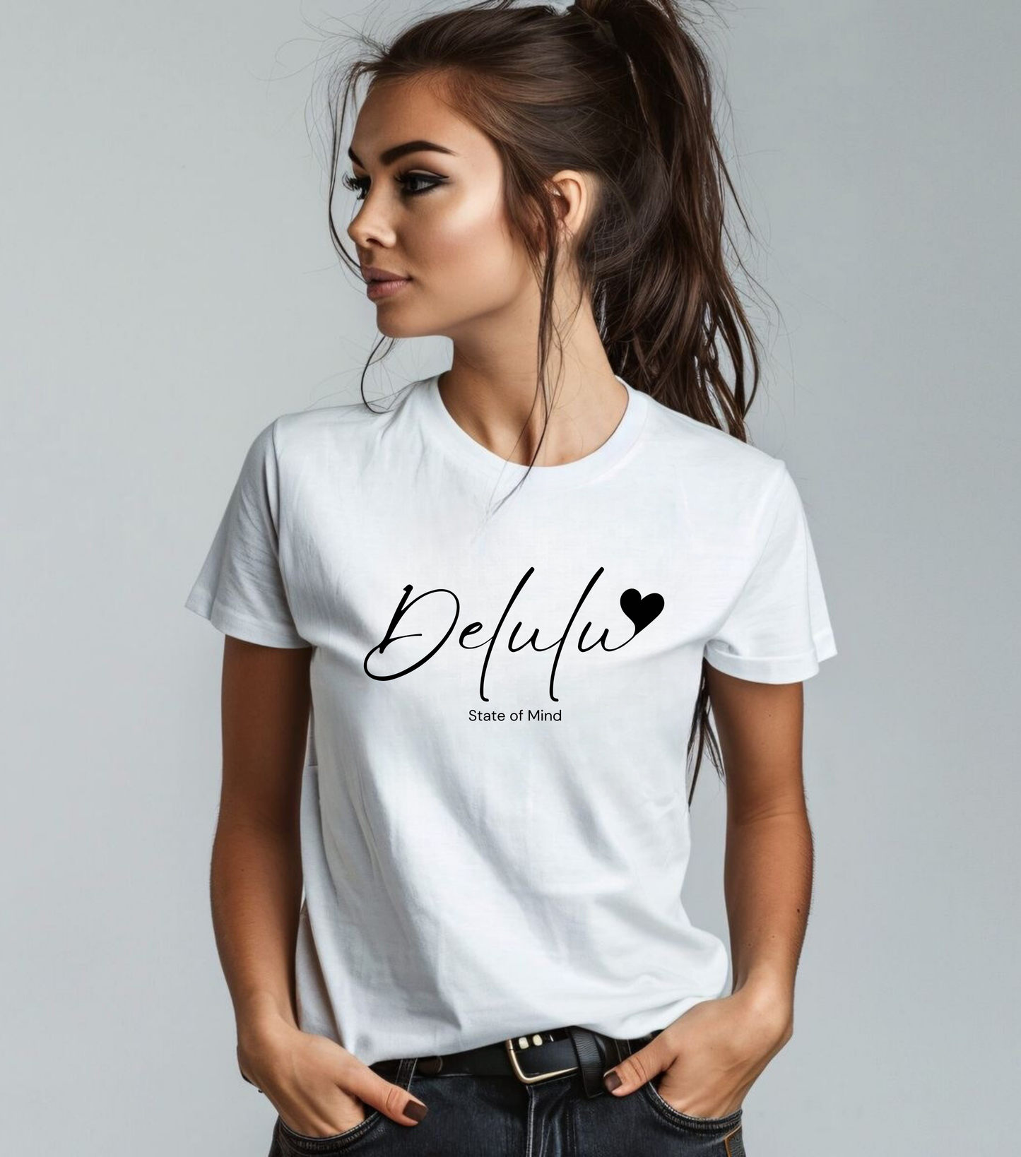 A female model wearing a white unisex short-sleeve t-shirt with the text 'DELULU' printed on the front.